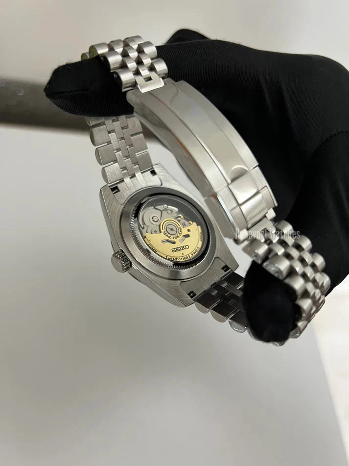 Datejust (Wimbledon Grey) Seiko NH35 automatic mod watch. A caseback detail showing the mechanical movement with a gold rotor and a silver jubilee bracelet.