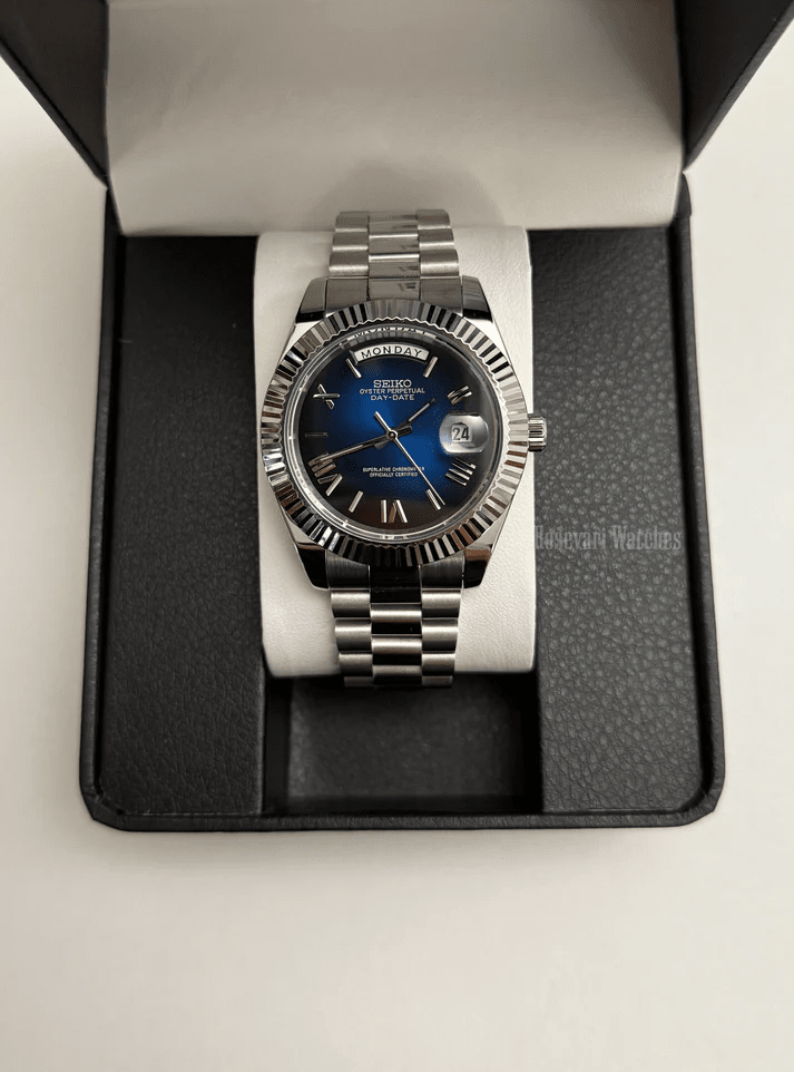 Day-Date (Blue Roman) Japanese automatic mod watch. A watch in a box with a blue dial and silver fluted bezel on a silver metal bracelet.