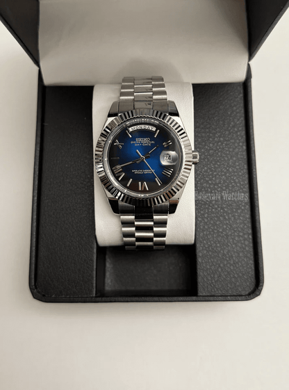 Day-Date (Blue Roman) Japanese automatic mod watch. A watch in a box with a blue dial and silver fluted bezel on a silver metal bracelet.