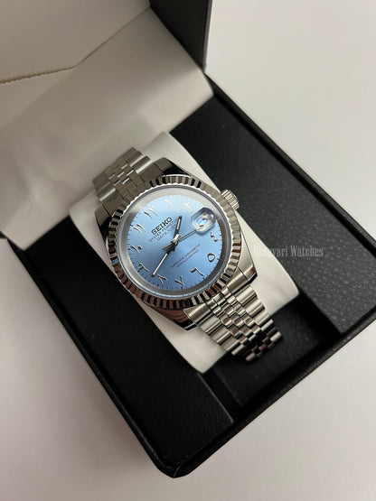 Datejust (Arabic Blue) Seiko NH35 automatic mod watch. A full watch shot inside a black box featuring a light blue dial and silver fluted bezel on a metal band.