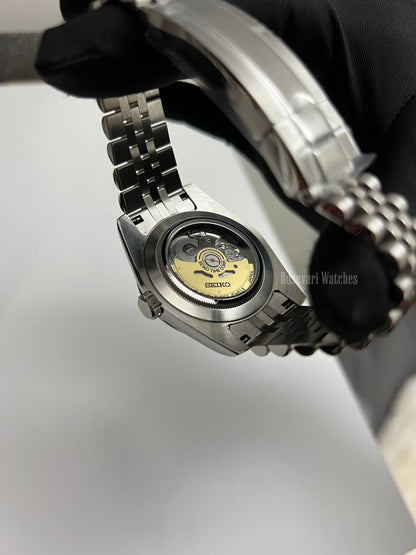 Datejust (Arabic Blue) Seiko NH35 automatic mod watch. A caseback detail shot showing the internal mechanical movement of the watch with a metal link bracelet.