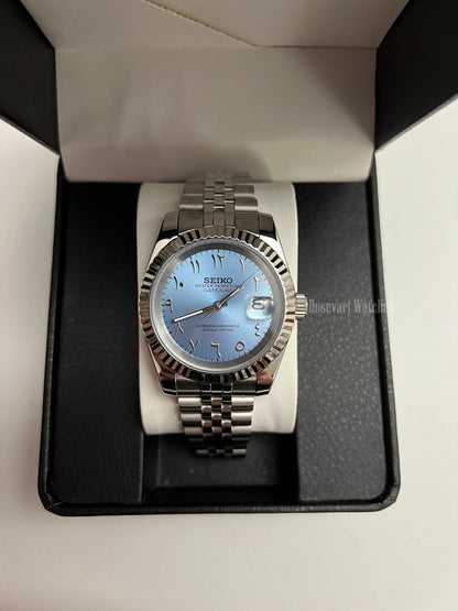 Datejust (Arabic Blue) Seiko NH35 automatic mod watch. A full watch shot inside a black box featuring a light blue dial and silver fluted bezel on a metal band.