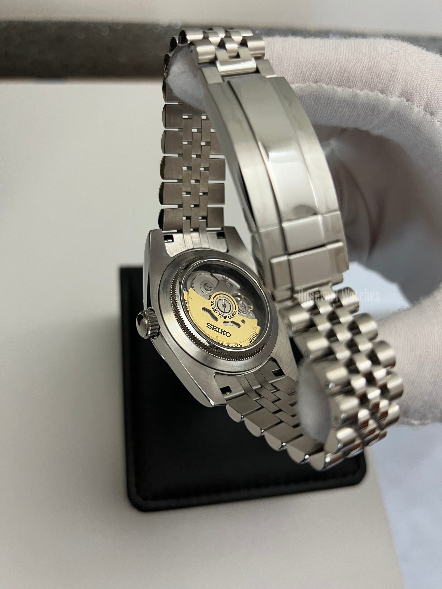 Datejust (Black Roman) Seiko NH35 automatic mod watch. A view of the watch caseback showing the mechanical movement and the jubilee bracelet in a side shot.