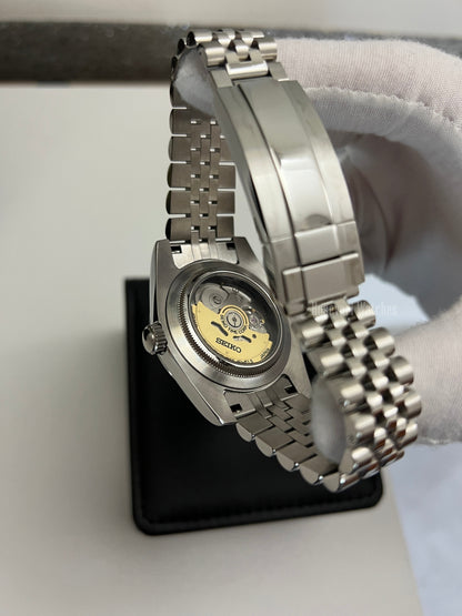Datejust (Black Roman) Seiko NH35 automatic mod watch. A view of the watch caseback showing the mechanical movement and the jubilee bracelet in a side shot.