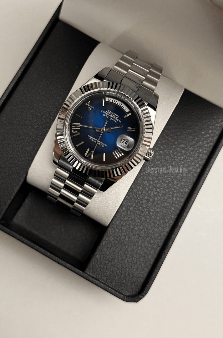 Day-Date (Blue Roman) Japanese automatic mod watch. A watch in a box with a blue dial and silver fluted bezel on a silver metal bracelet.