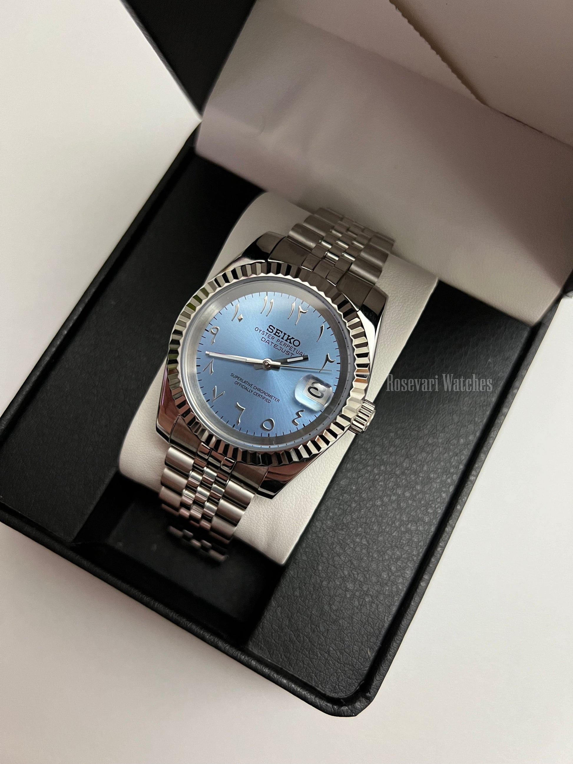 Datejust (Arabic Blue) Seiko NH35 automatic mod watch. A full watch shot inside a black box featuring a light blue dial and silver fluted bezel on a metal band.