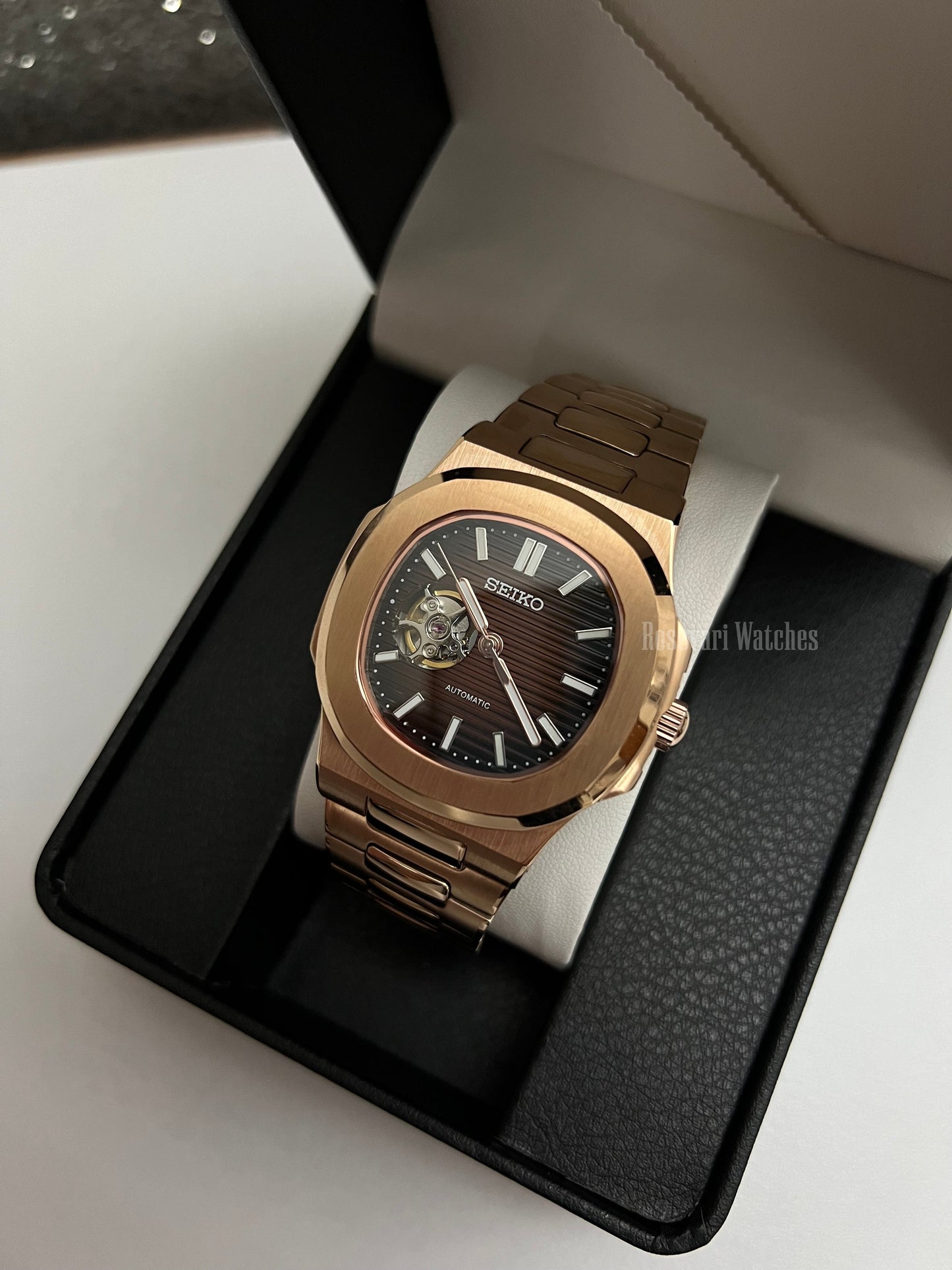 Nautilus (Open Heart, Chocolate) Seiko NH38 open-heart automatic mod watch. A full watch shot inside a box showing a brown dial with an open heart and a rose gold bracelet.