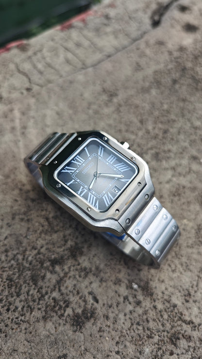 Santos (Graphite) Seiko NH35 automatic mod watch. A side angle full watch shot displaying a grey dial with a black bezel and a metal link bracelet.