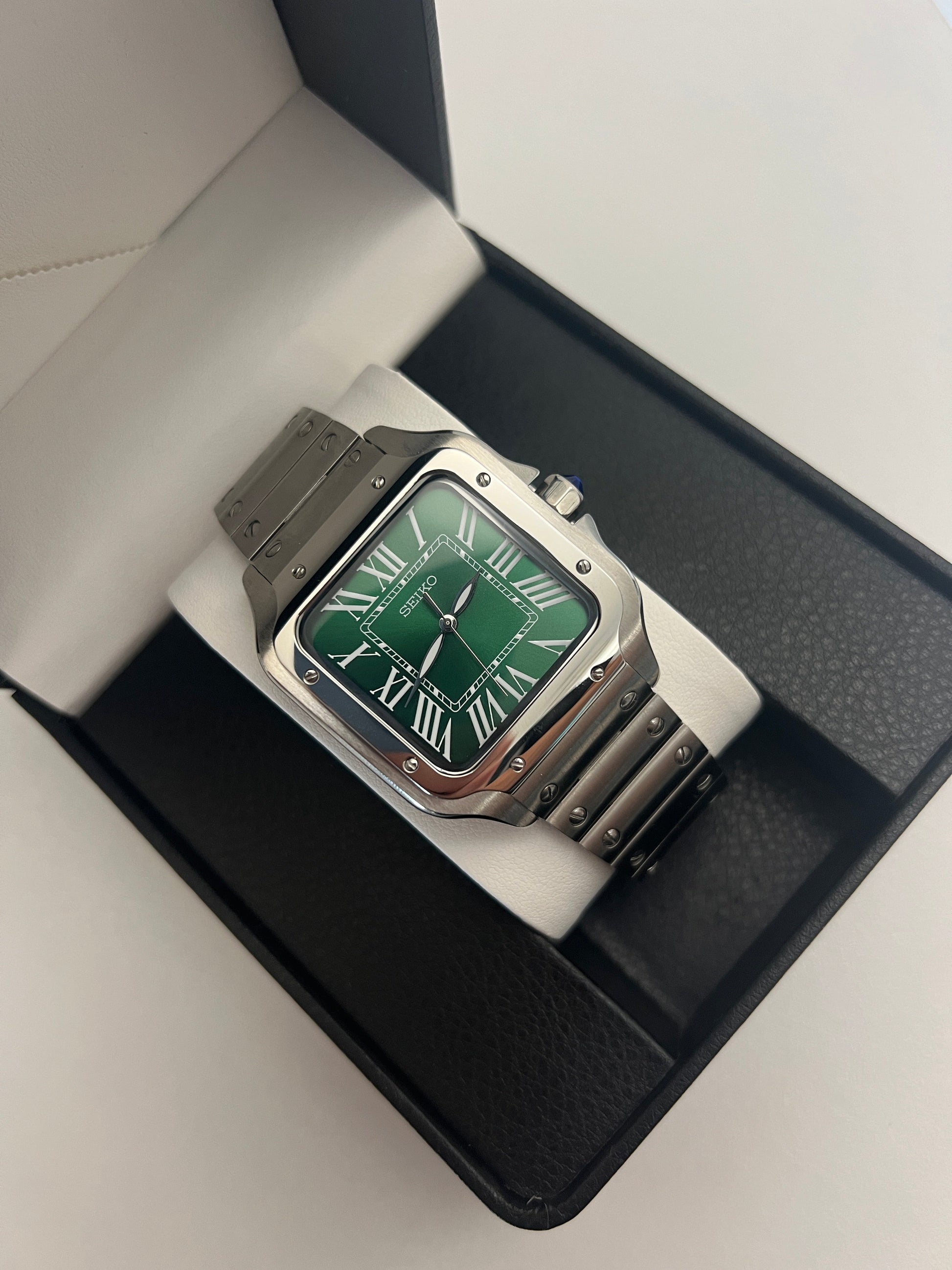 Santos (Emerald Green) Seiko NH35 automatic mod watch. A full watch shot inside a box showing a green dial and silver bezel with a metal bracelet.